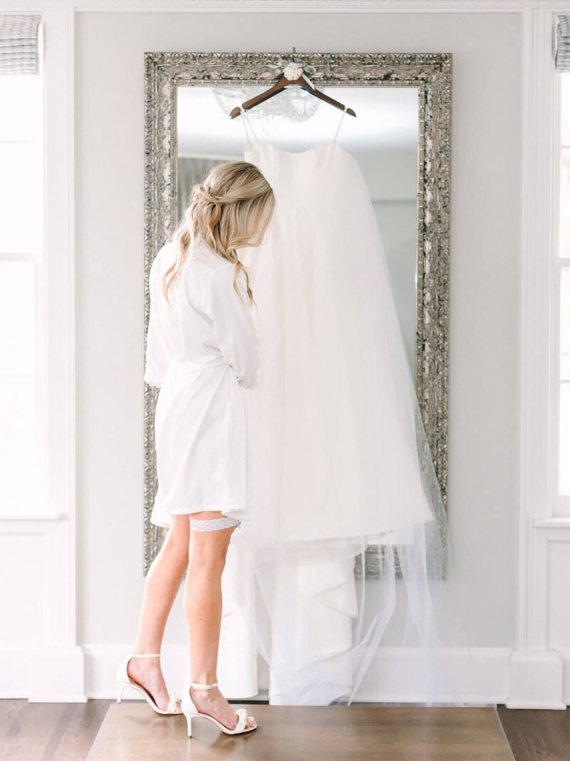 bride looking at wedding gown by event planners minneapolis