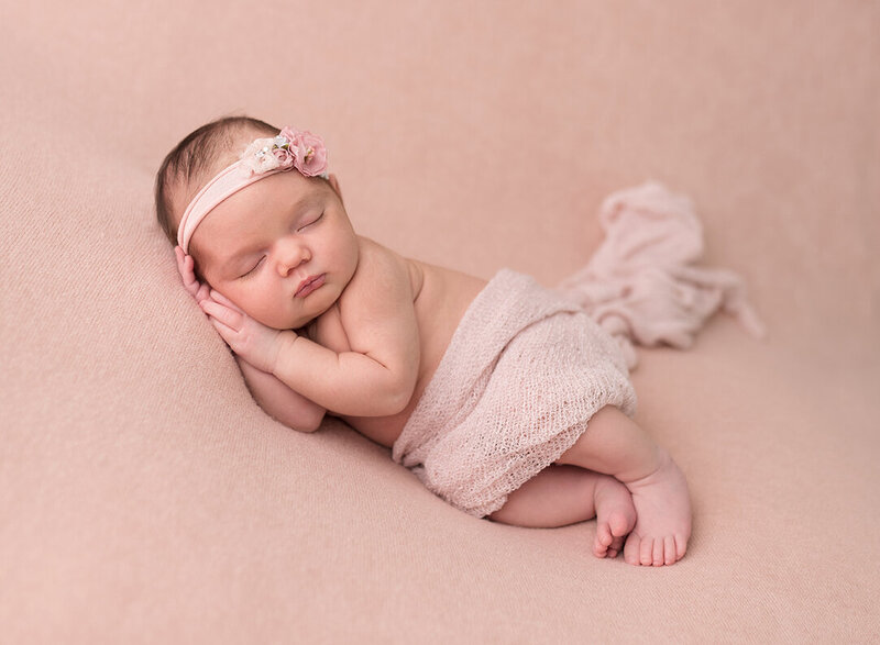 Cute newborn in pink flower headdress  by Laura King Photography