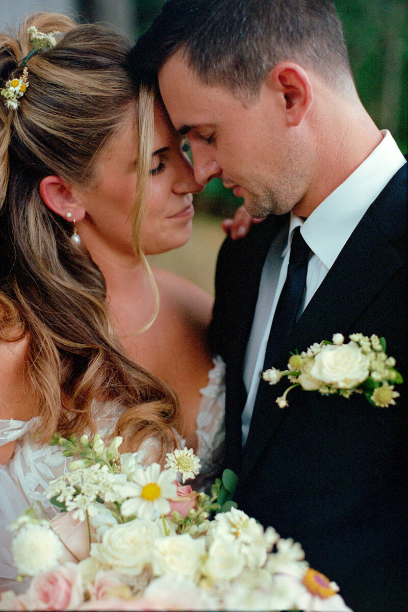a bride and groom share a intimate moment with beautiful florals