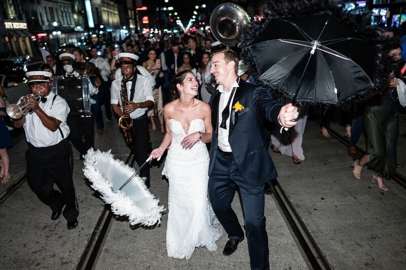 Bride and groom in second line parade down St. Charles Avenue in New Orleans