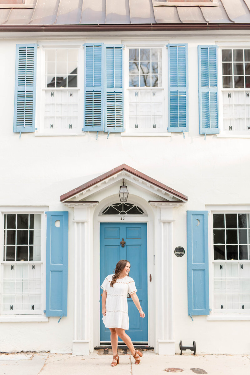Katie standing in front of a charming white and blue house