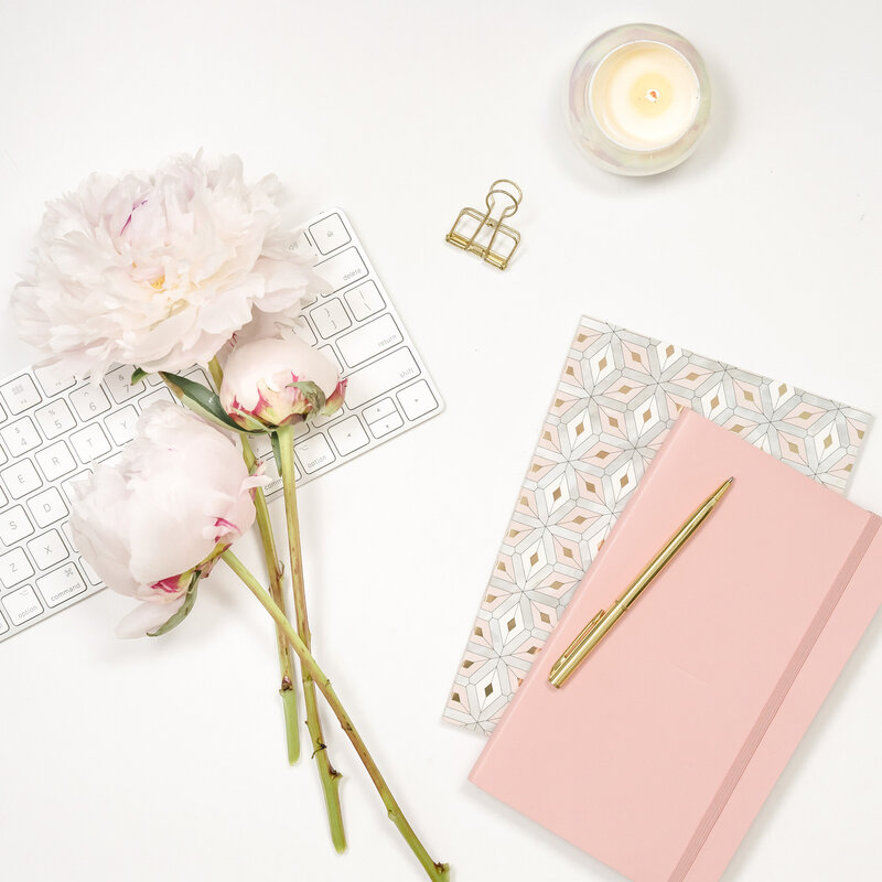 pink flowers and notebook on desk