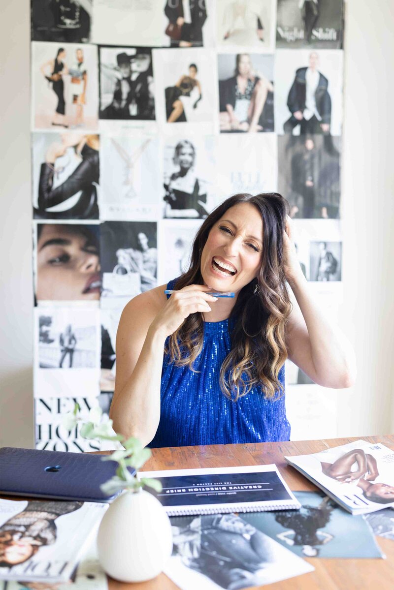 woman laughing with tear sheets in the background