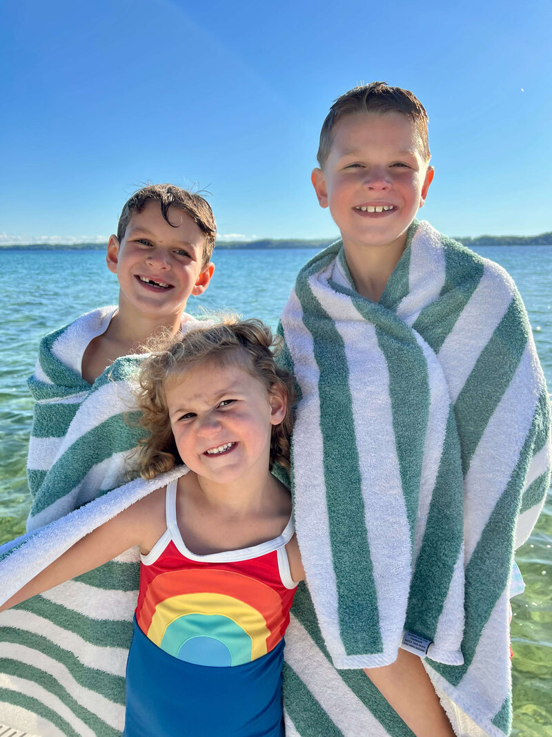 Alison and Jon's family smiling at camera after swim