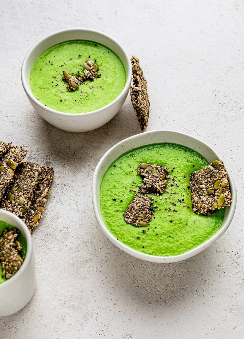 Green Goddess Menopause Abundance Bowl – vibrant pea soup topped with crunchy seed crackers, a nourishing and protein-rich recipe from Menopause.Rescripted®