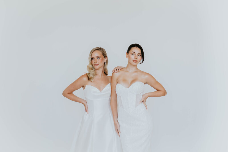 bridal stylist smiling among dresses