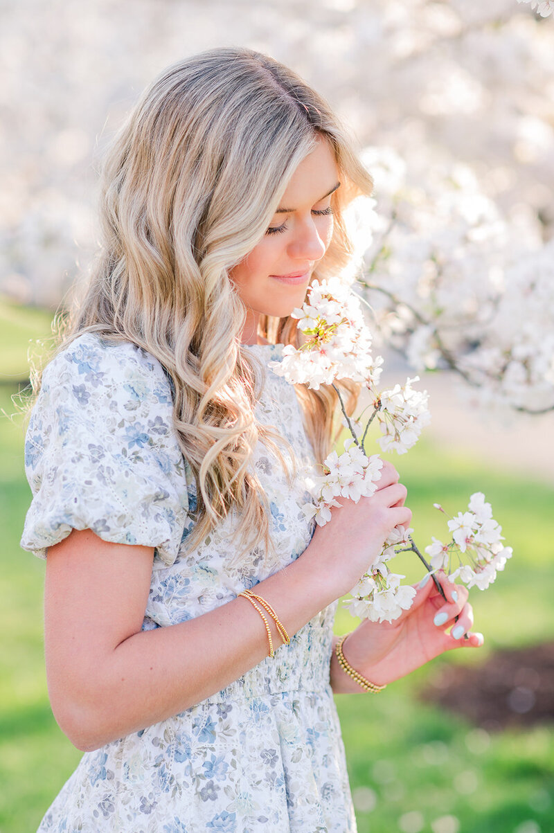 girl in a floral dress holding a flower