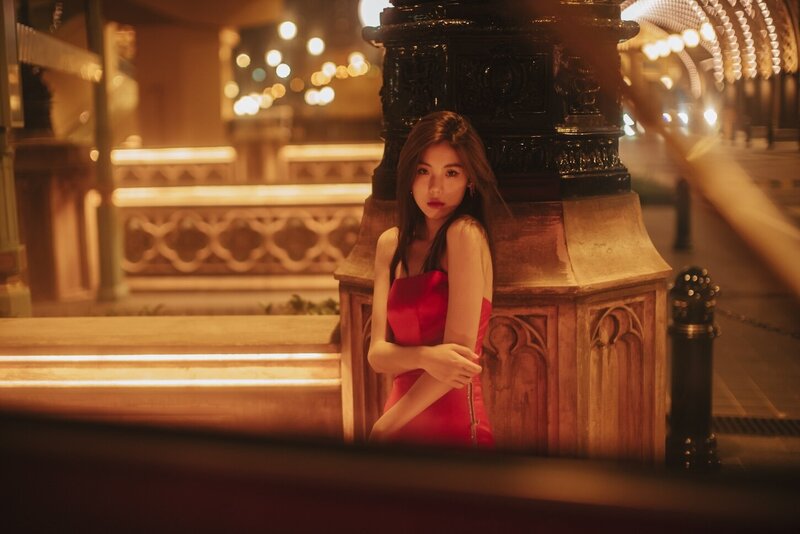 Destination couture photoshoot with a woman in. a red gown at night in the city.