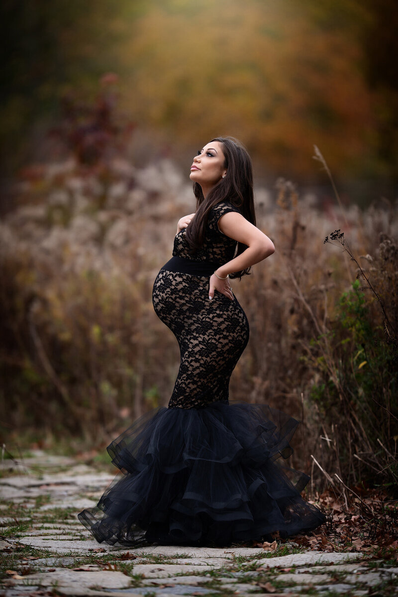 Pregnant woman wearing black lace gown taken by Detroit Maternity Photographer Kat Figlak