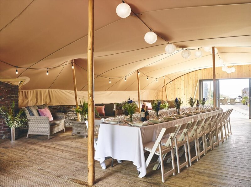 The Polhawn Terrace marquee set up for a small dinner with one long table