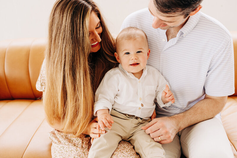 baby with his parents in an indoor natural light studio