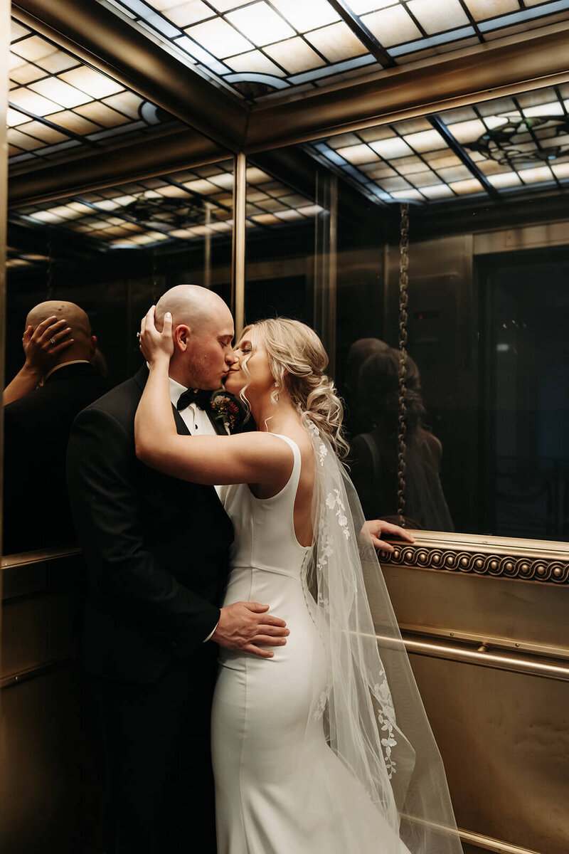 Bride and groom kiss in elevator