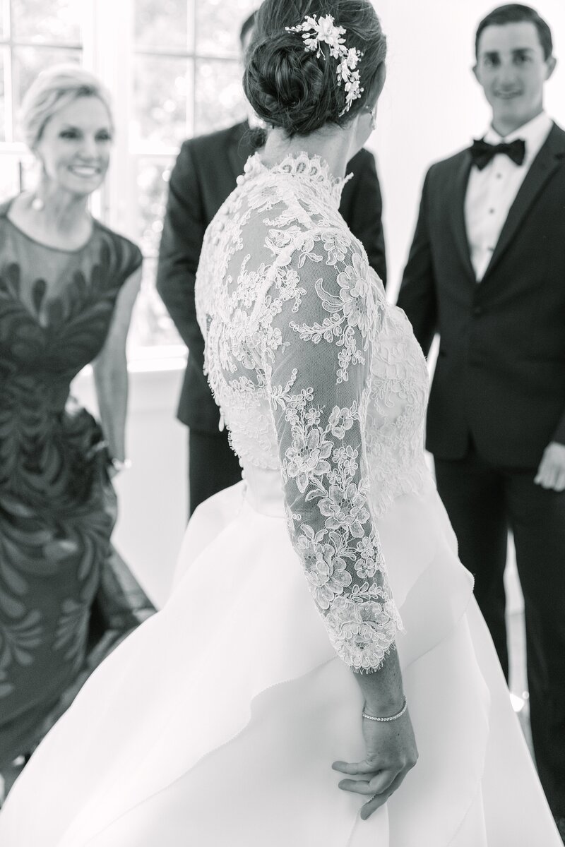 bride twirls in front of her family, showing off her lace wedding dress