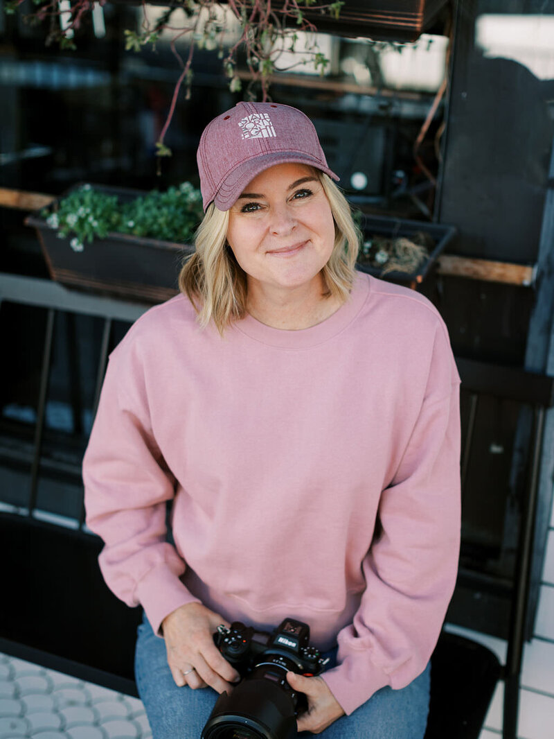 A woman in a pink sweater and hat smiling.