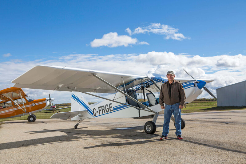 man stands in front of small airplane