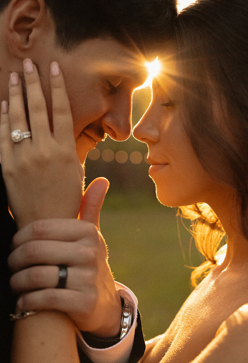Golden hour sunlight shining between bride and groom