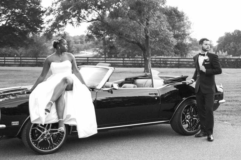 bride and groom pose outside charlotte ceremony site in vintage car
