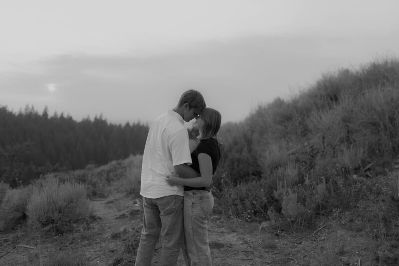 A black and white photo of a couple in Rexburg, Idaho. They're holding each other and touching foreheads.