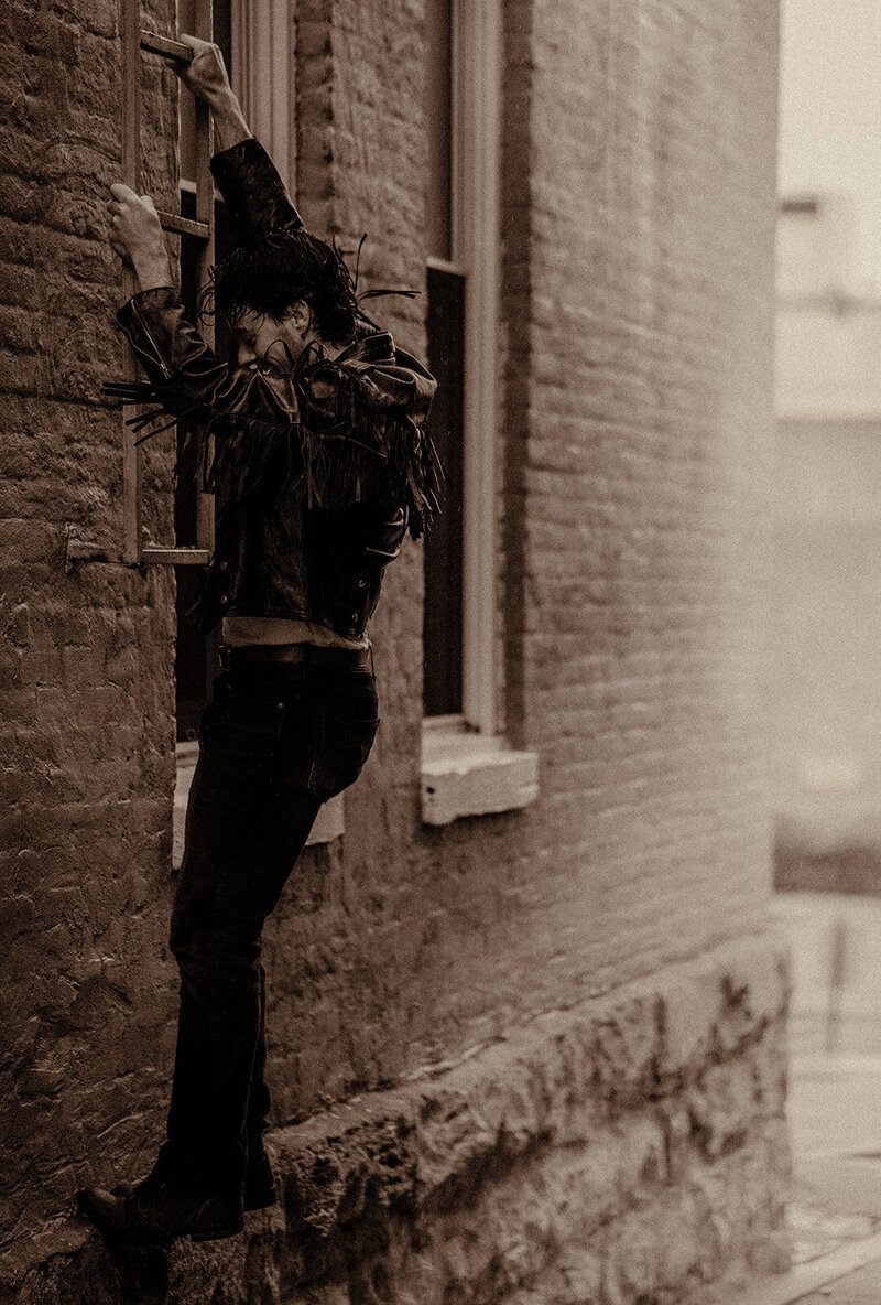 A Nashville rock musician wears a leather jacket for his album cover in the rain.