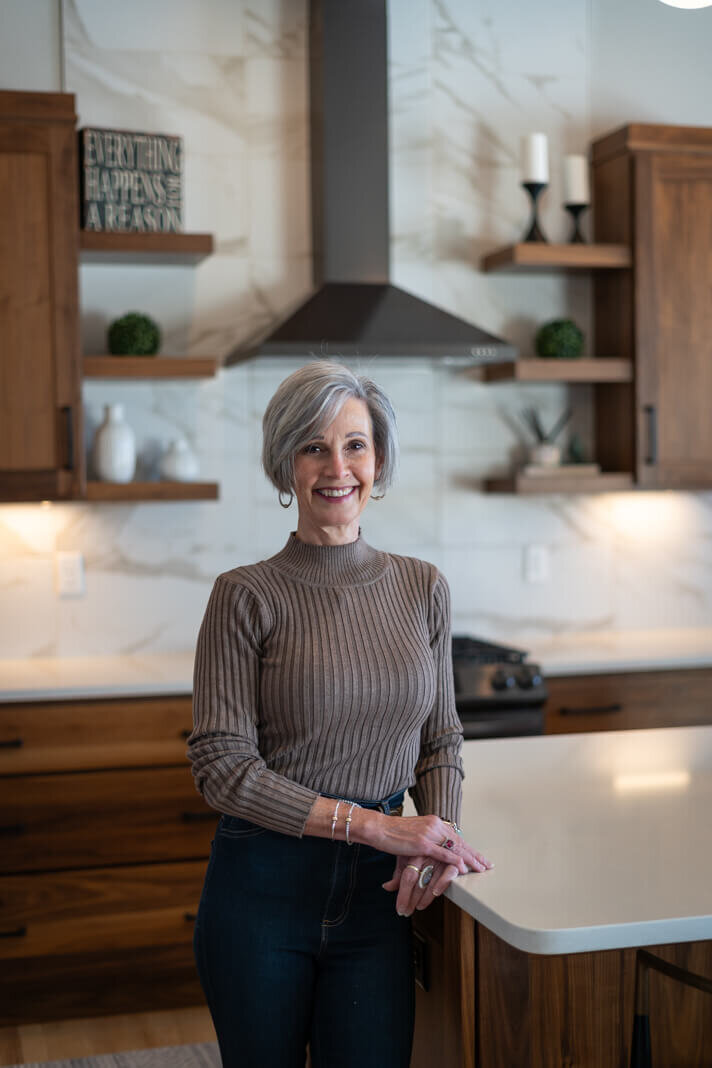 woman with gray hair smiling in a kitchen