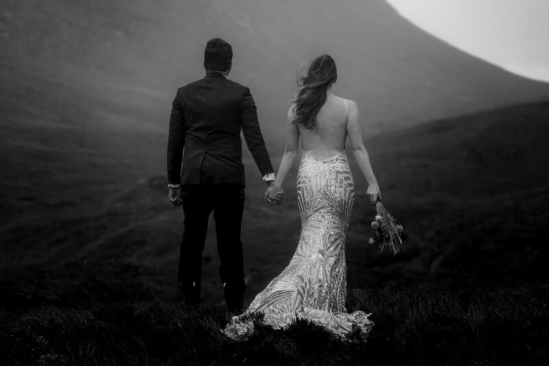 Glencoe Elopement in black and white bride and groom look to mountain