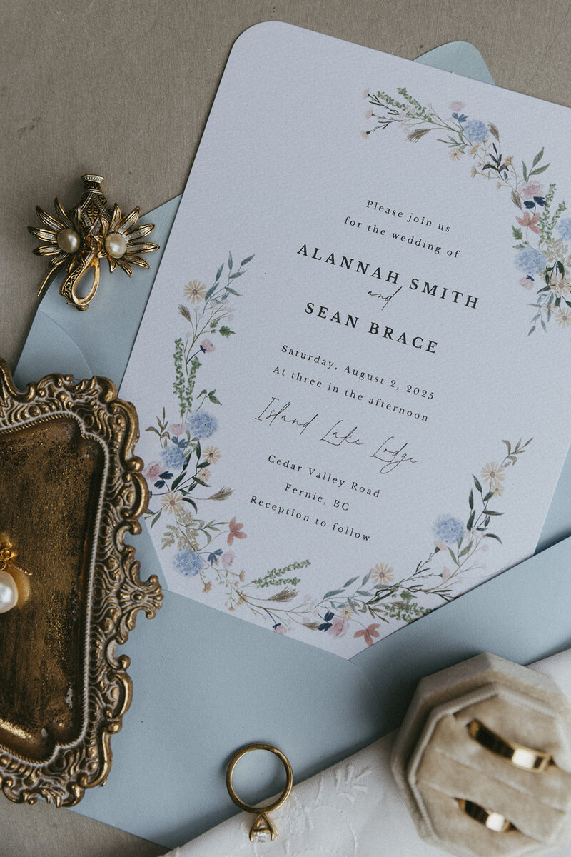 detail photo of invitation suite and rings at BC wedding