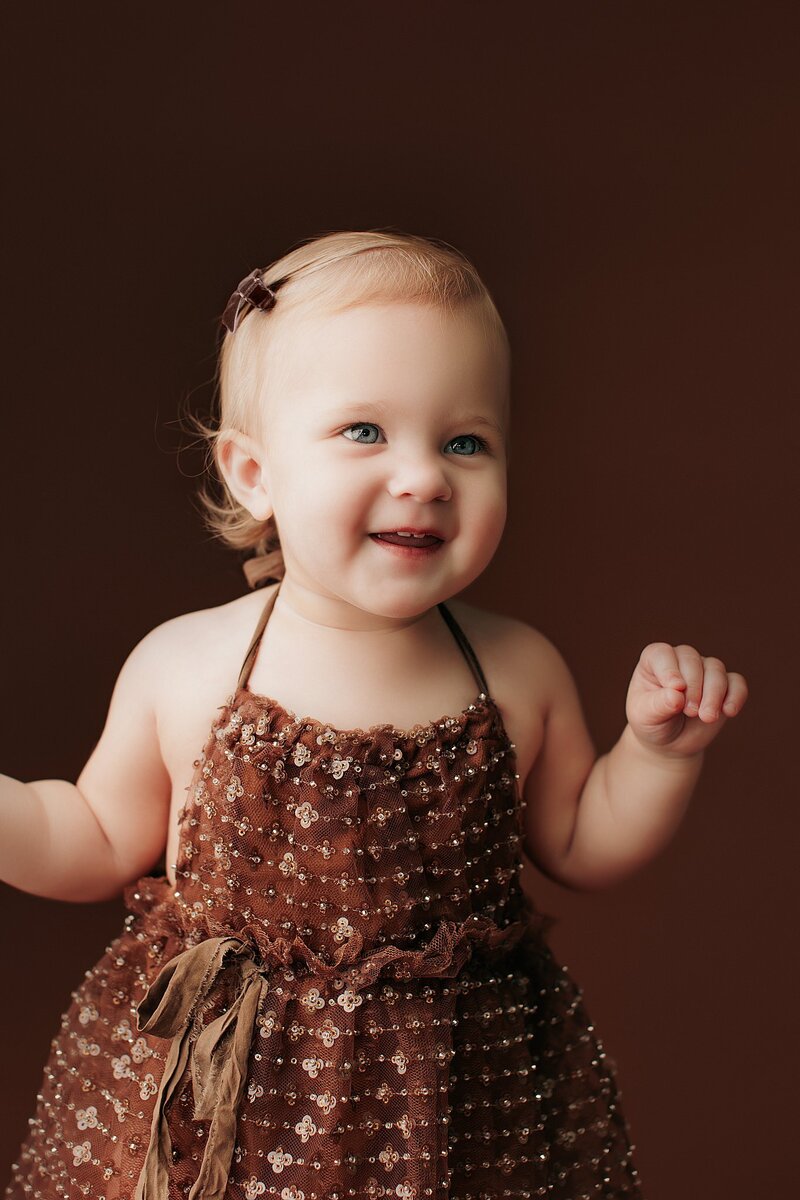 Baby wearing ruffled romper during studio milestone shoot in Austin