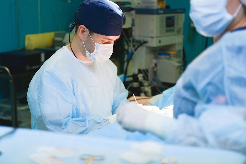 male surgeon in blue cap with nurse