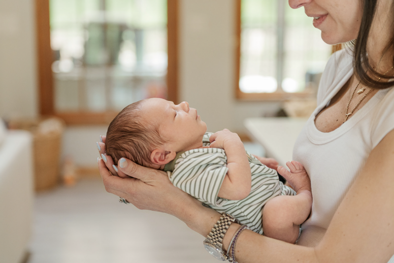 Newborn cuddled in mom’s arms during in-home lifestyle session – Harrisburg, PA newborn photographer