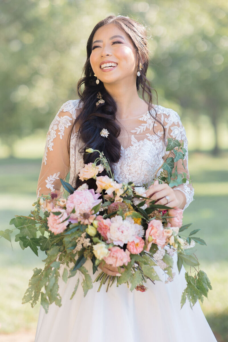 Bride stands with flowers outside the Great Marsh Estate in Richmond Virginia