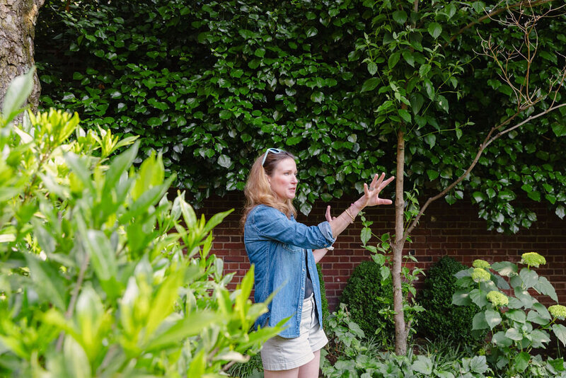 Woman with light brown blonde hair wearing denim blouse directing the landscaping architects