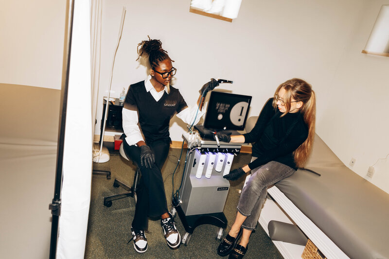A student learning how to use a Hydrafacial machine, one of the advanced skincare treatments at Savant Aesthetics Institute.