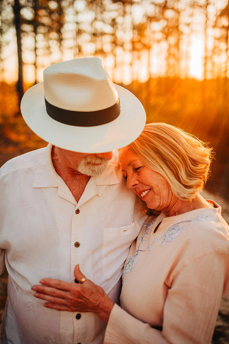 an older couple embracing in a hug engulfed by a gorgeous golden sunset