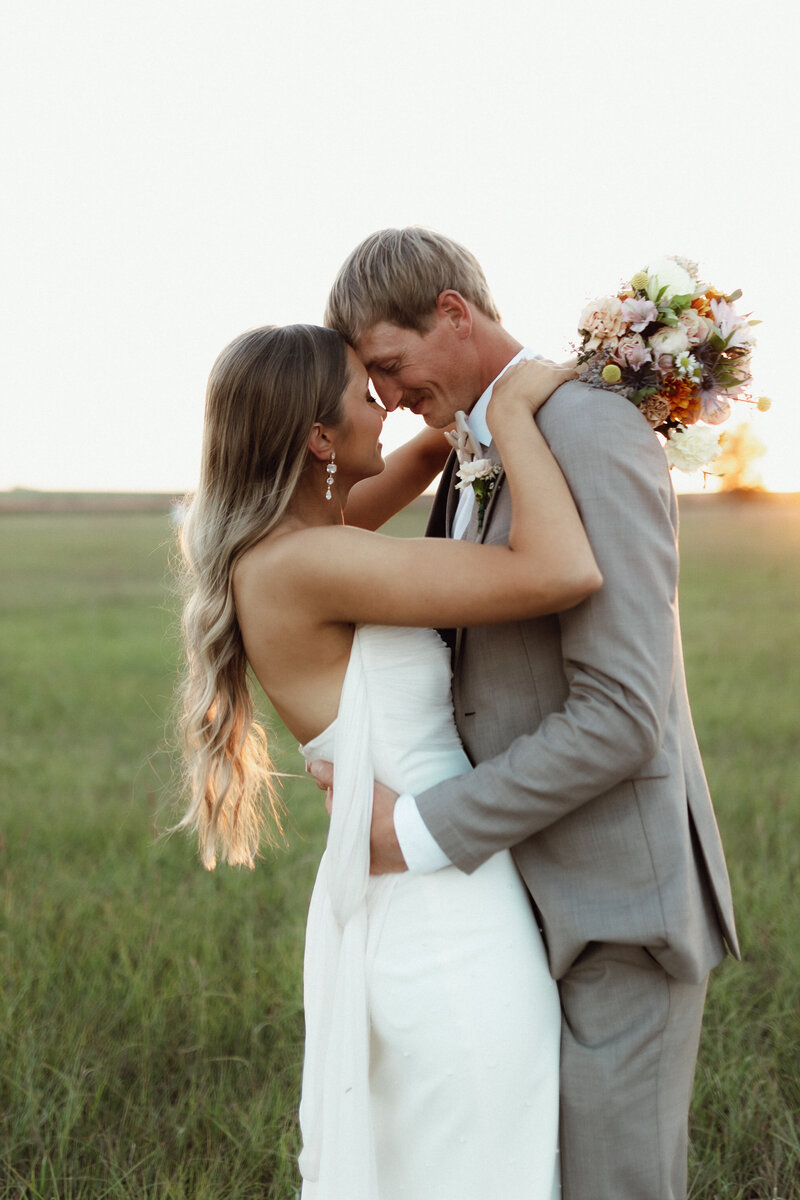 bride and groom| Kansas Wedding photographer| Bride and groom dancing in a field. Long hair bridal hairstyle 