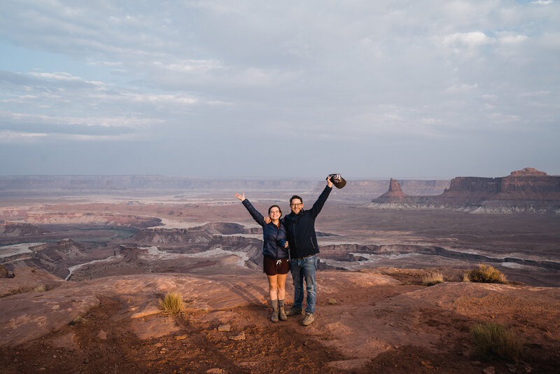 couple smiling on top of a canyon rim