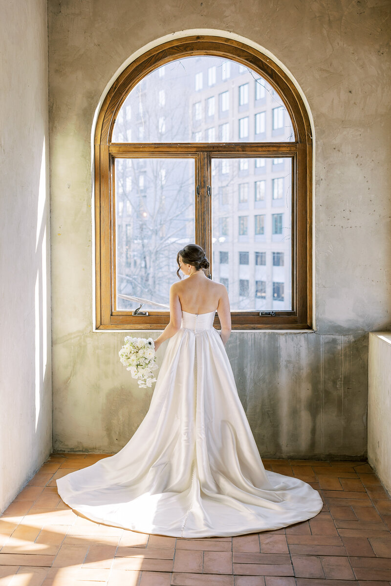 bride standing in front of the window