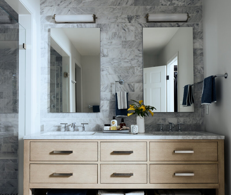 Interior designers in Boston transformed a historic home bathroom with a modern vanity, blending old architectural details with fresh, contemporary design.