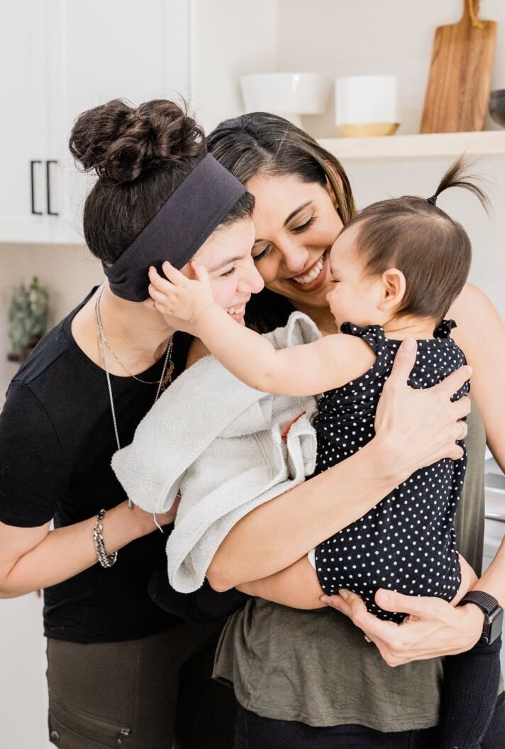 Lesbian couple holding their daughter