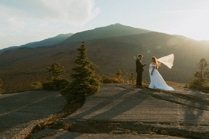 Bride and groom exchanging vows on the summit of Pine Mountain in Gorham, New Hampshire during their fall elopement as the sun sets.