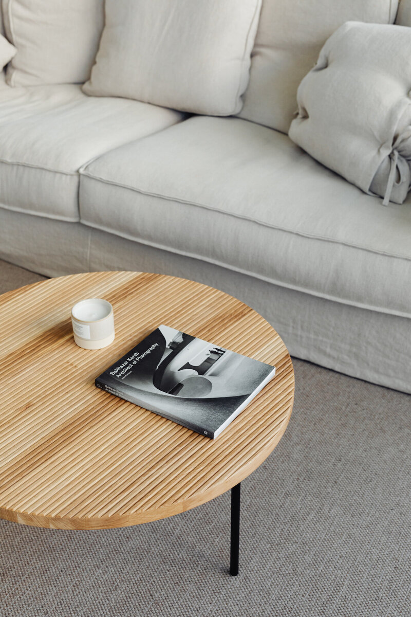 kaboompics_wooden-coffee-table-book-candle-linen-sofa-pillows-carpet-22043