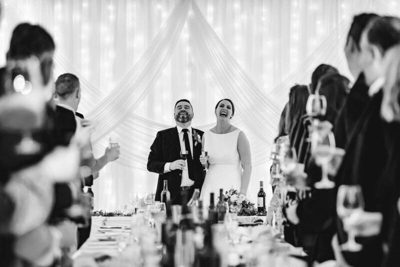 Bride and groom laughing at wedding reception