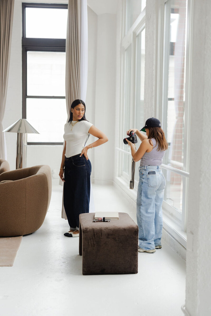 A photographer fixing a models hair on set in a photo studio rental in Chicago.