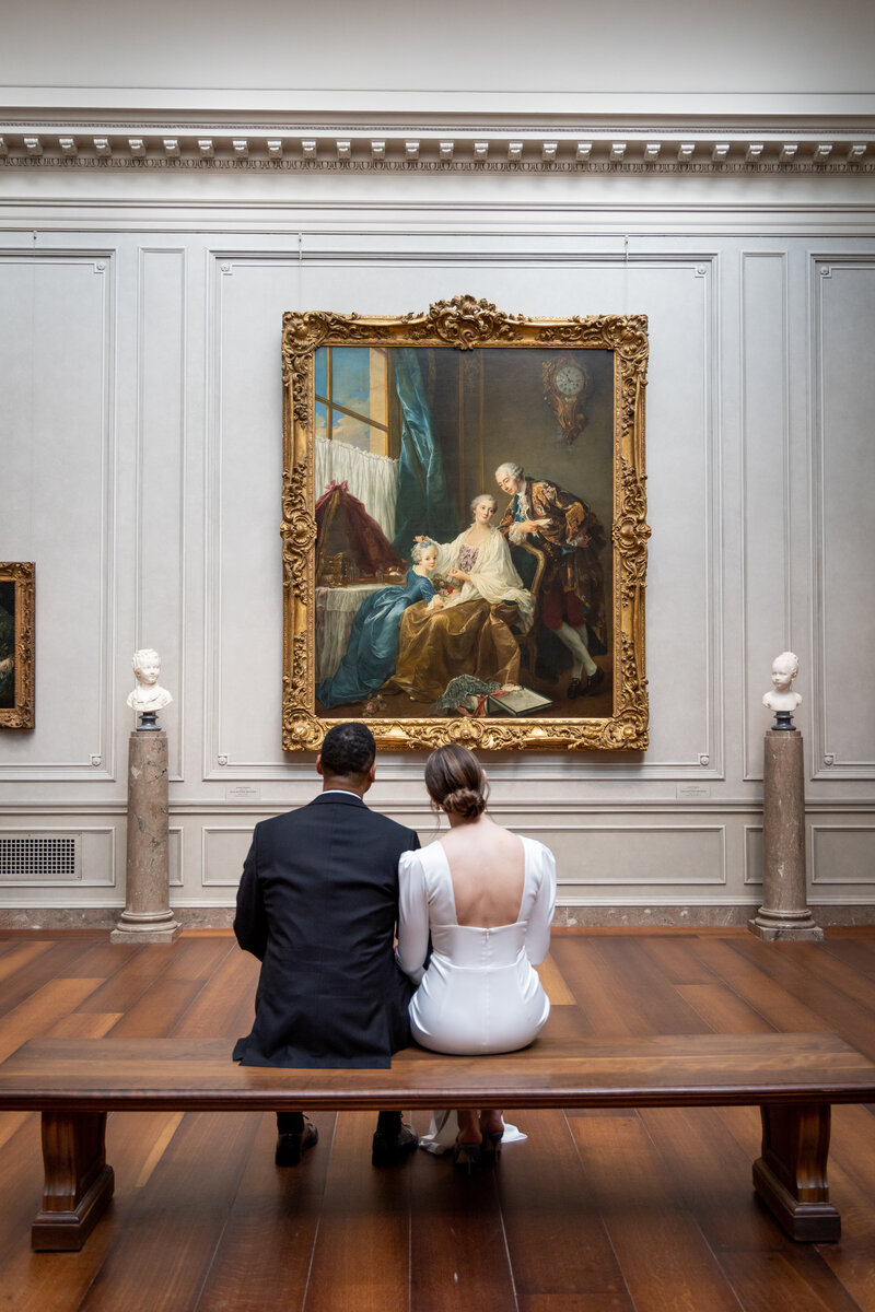 bride and groom staring at art in a museum