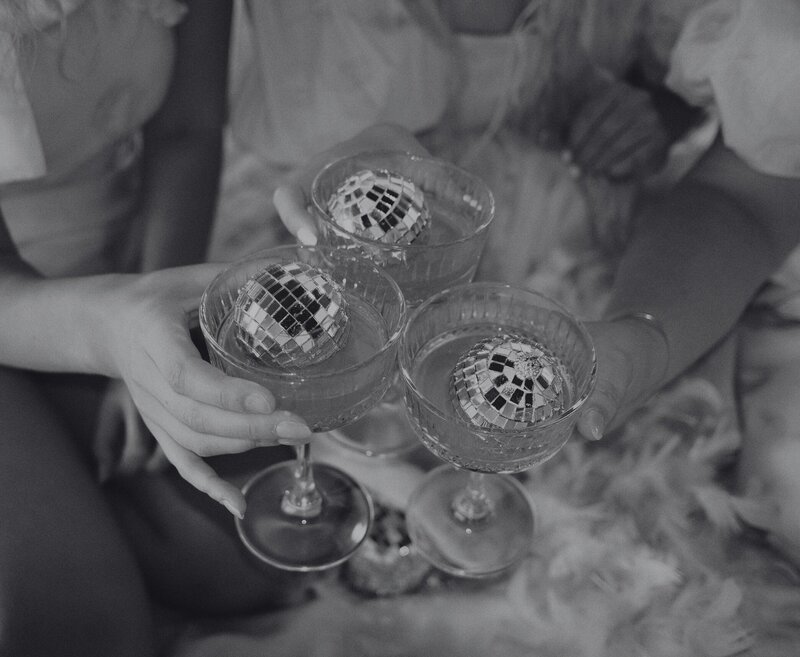 three glasses cheering with a small disco ball in each