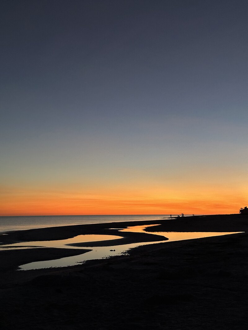 The last minutes of sunset in Florida, with colored light reflecting off the pools left by the receding tide.