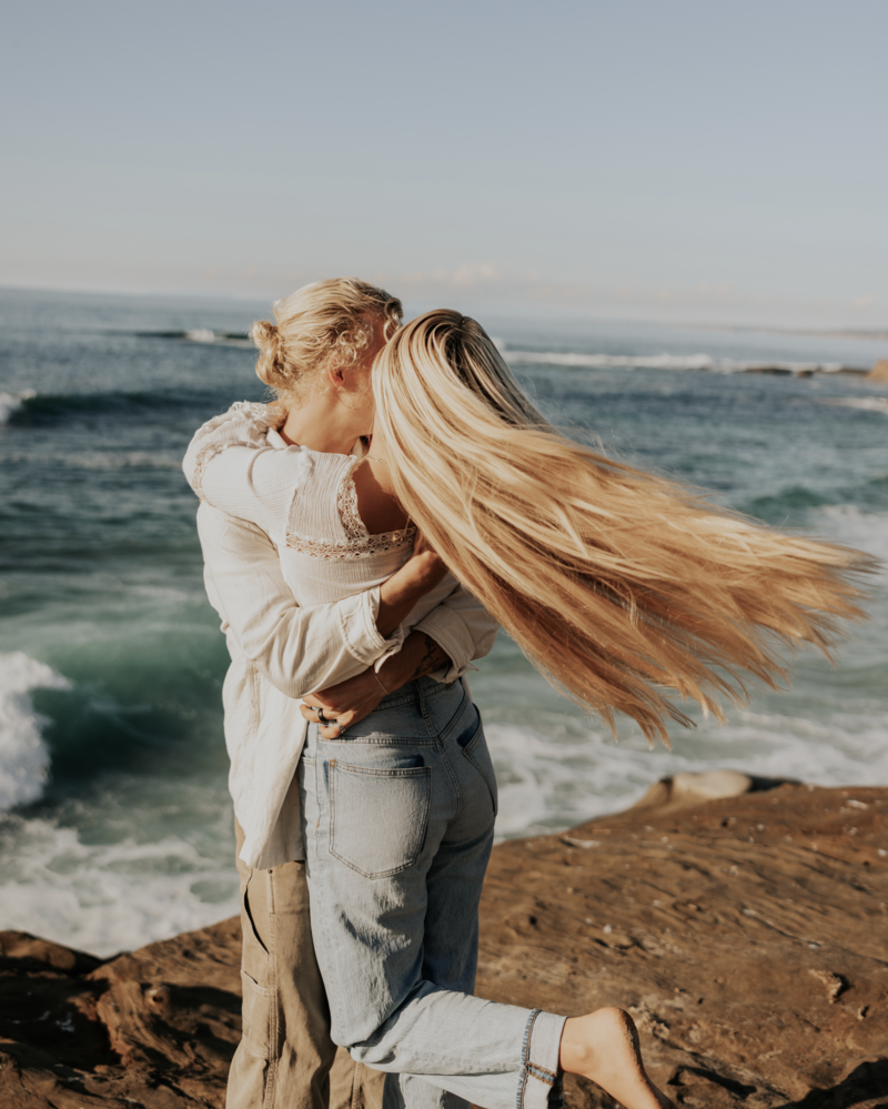 Guy swinging a girl around at the beach