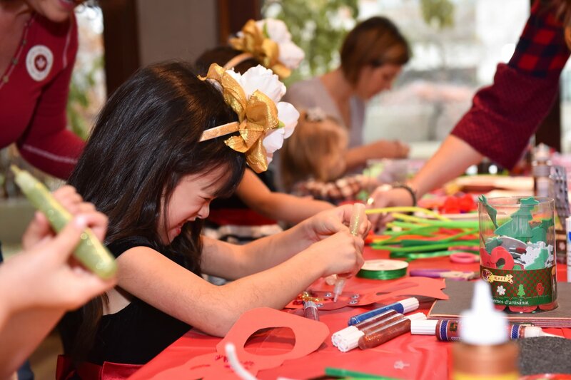 Santa Claus engaging with children and parents at a lively holiday party, spreading festive cheer and creating memorable moments