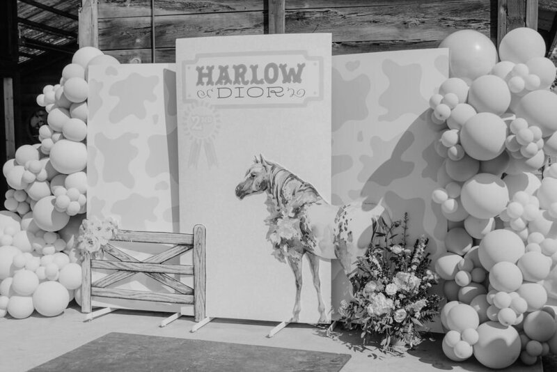 Black and white image of signage and balloon arch for pony themed party planned by Fancy Chancey in San Diego CA
