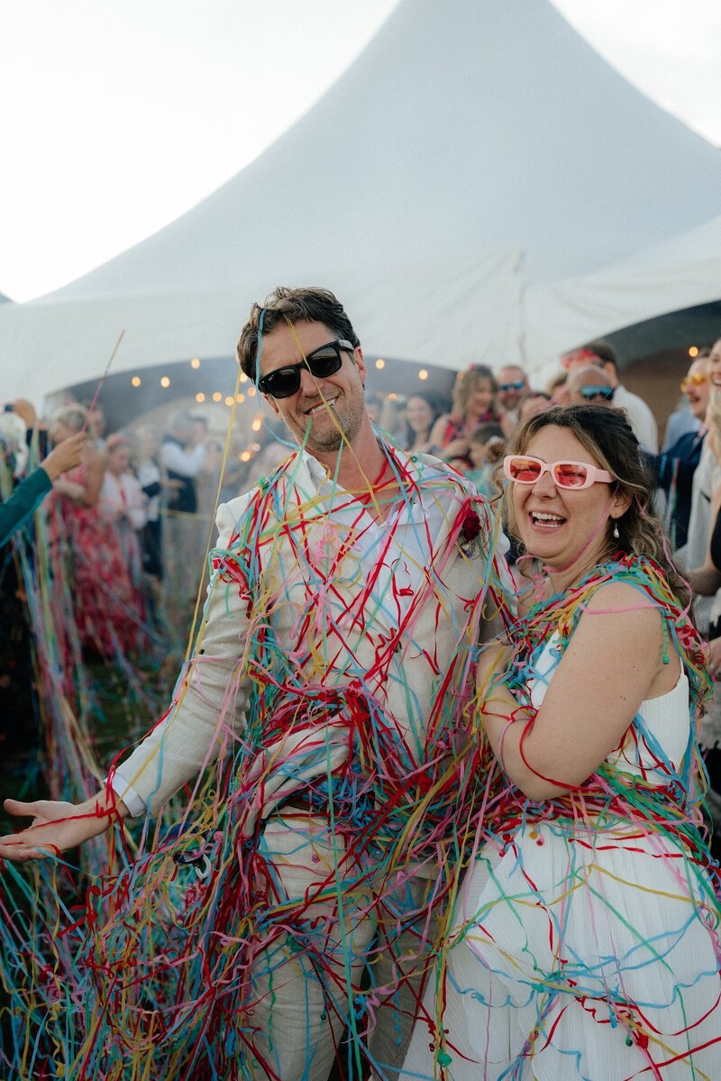 Guests celebrating with colorful streamers at a joyful wedding reception in Seward, Alaska, photographed by Emelia K Photography.