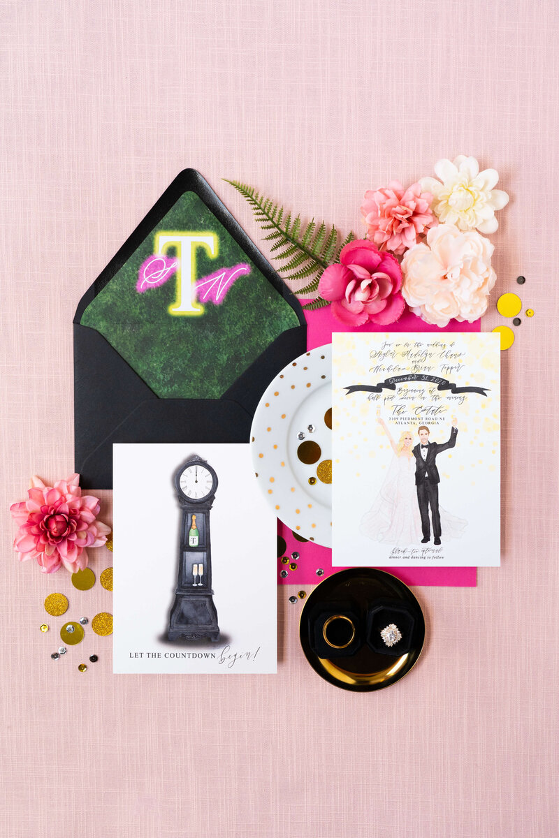 Modern and classic black wedding invitations with a neon sign envelope liner, designed for a New Year's Eve wedding. Includes a watercolor portrait of the bride and groom and a countdown to their wedding.
